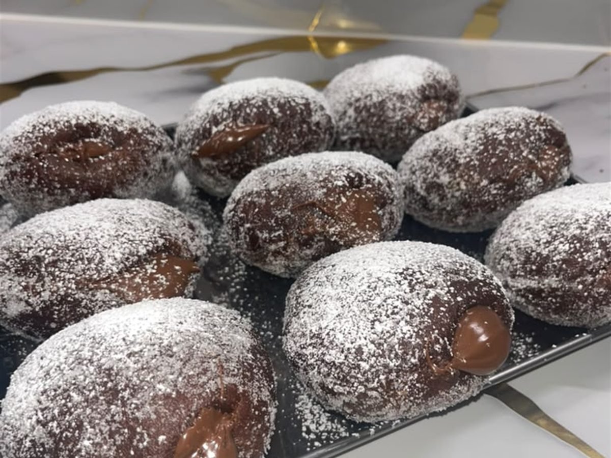 Bombas rellenas bañadas en chocolate y espolvoreadas
